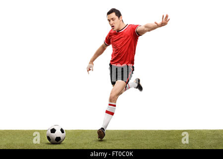 Young football player shot in the moment right before kicking a ball isolated on white background Stock Photo