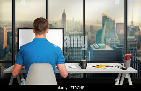 Man working on computer with isolated screen in office interior overlooking the city and skyscrapers. Work desk with keyboard, m Stock Photo