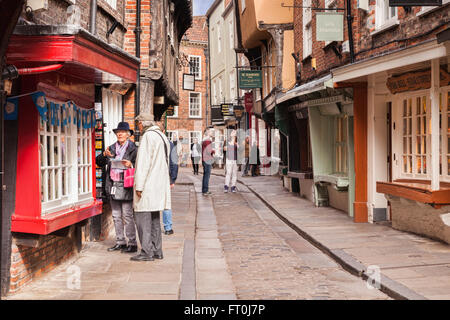 Senior couple shopping in The Shambles, York, North Yorkshire, England, UK Slight motion blur on woman's face at large sizes.