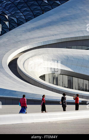 Detail of exterior facade with visitors. Harbin Opera House, Harbin, China. Architect: MAD Architects, 2015. Stock Photo