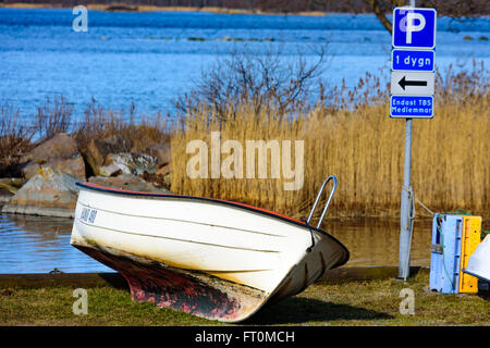 Torhamn, Sweden - March 18, 2016: One small outboard motorboat parked at a parking place on land. The sea in the background. Stock Photo