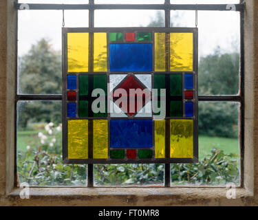 Close-up of a window with a hand made stained glass decorative hanging Stock Photo