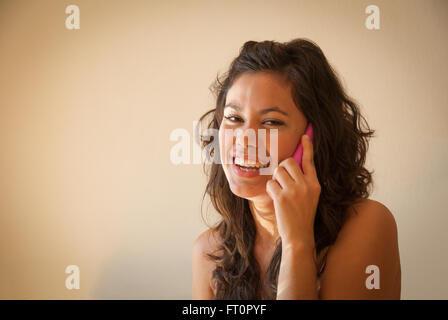 Laughing young Hispanic woman using cell phone - Puerto Vallarta, Bahia de Banderas, Pacific Ocean, Jalisco, Mexico  #613PV Stock Photo