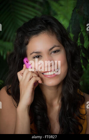 Smiling young Hispanic woman with cell phone - Puerto Vallarta, Mexico  #613PV Stock Photo