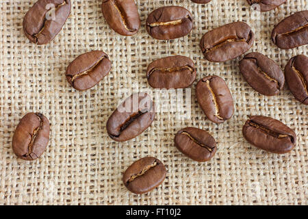 Coffee beans on burlap background. Close up. Stock Photo