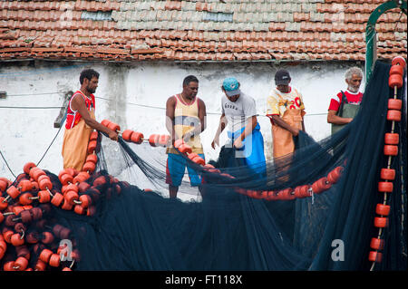 Fishermen checking fishing net in harbour, Cabo Frio, Rio de Janeiro, Brazil Stock Photo