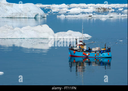 Fishing boat between icebergs and ice floes, Ilulissat Kangerlua Icefjord, Ilulissat, Qaasuitsup, Greenland Stock Photo