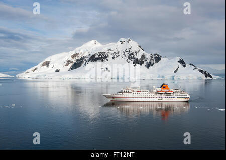 Expedition cruise ship MS Hanseatic Hapag-Lloyd Cruises and ice covered mountains, Lemaire Channel, near Graham Land, Antarctica Stock Photo