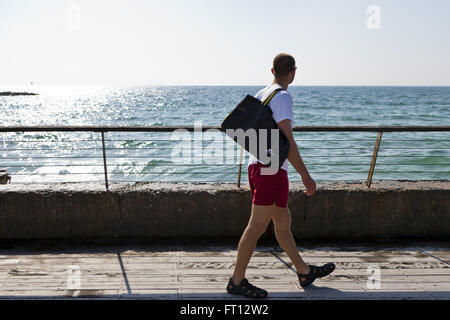 Man walking along the port looking out to the Mediterranean Sea, Tel-Aviv, Israel, Asia Stock Photo
