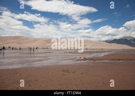 A view of the Medano River in the Great Sand Dunes National Park with tourists. Stock Photo
