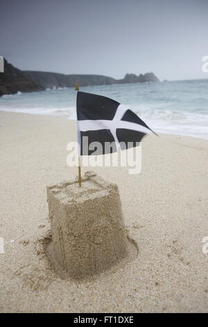 A sandcastle with the cornish flag on a beach in cornwall Stock Photo