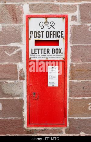 GR vi (six) wall mounted post office letter box in British red colouring at the general store in Luss, Scotland, UK Stock Photo