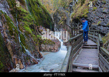 Tourist looking at waterfall in gorge Wimbachklamm in Ramsau bei Berchtesgaden, Berchtesgaden National Park, Bavaria, Germany Stock Photo