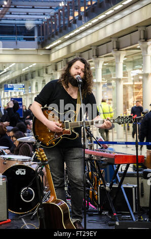 John Joseph Brill performing a 30 minute set at a  pop-up concert in St Pancras International Railway Station. Stock Photo