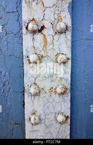 Industrial grunge background with patterns and textures of flaking blue paint and rivets on corroded metal plates Stock Photo