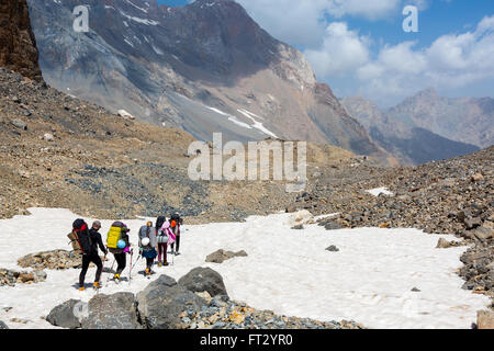 Group of Hikers Walking on Snowfield Stock Photo