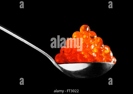 The spoon with red caviar on a black background Stock Photo