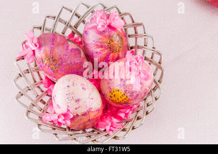 Pink decoupage decorated Easter eggs in a wicker basket Stock Photo