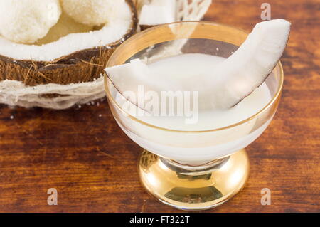 Coconut liqueur in glass served with fresh coconut Stock Photo