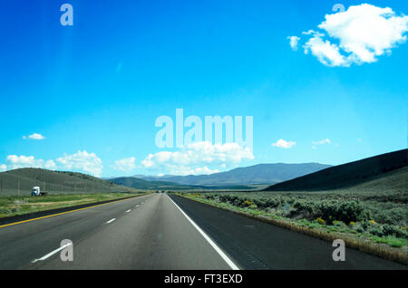 Freeway running through the open countryside, blue sky and white clouds. Stock Photo