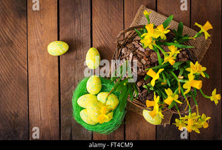 Easter eggs and flowers on a dark wooden background. Top view Stock Photo