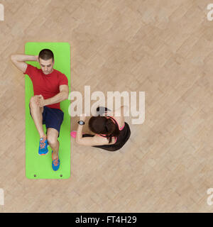 Fitness couple doing abs exercises on mat. Above image with copy space. Stock Photo