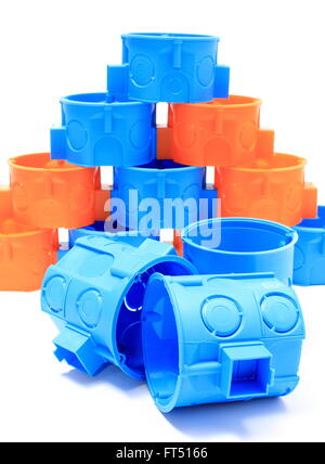 Blue and orange plastic electrical boxes on white background, components for use in electrical installations, Stock Photo