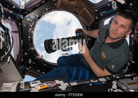Russian cosmonaut Yuri Malenchenko inside the Cupola module preparing to take Earth pictures using a 400 mm lens aboard the International Space Station March 5, 2016 in Earth Orbit. . The Cupola 360 degree viewing platform provides optimal views of the Earth below and also contains the control mechanisms for the station's Canadarm2 robotic arm.