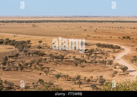 Car driving on dry, dusty road in drought conditions in western Queensland, high view point Stock Photo