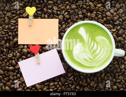 beautiful green tea and clip note on coffee bean background Stock Photo