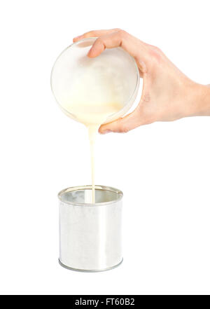 Woman hand pouring condensed milk into a tin can isolated on white Stock Photo