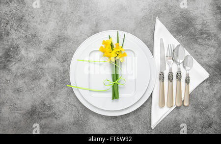 Table place setting with cutlery and spring flowers decoration. Top view Stock Photo