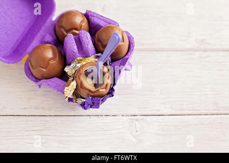 Small chocolate Easter eggs sat on a weathered wooden background Stock Photo