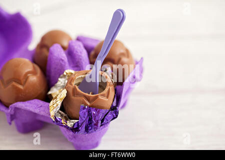 Small chocolate Easter eggs sat on a weathered wooden background Stock Photo