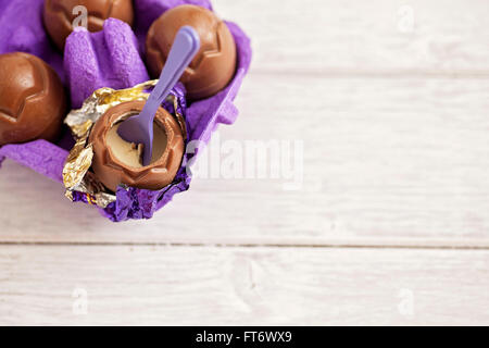 Small chocolate Easter eggs sat on a weathered wooden background Stock Photo