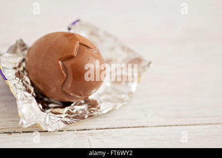 Small chocolate Easter eggs sat on a weathered wooden background Stock Photo