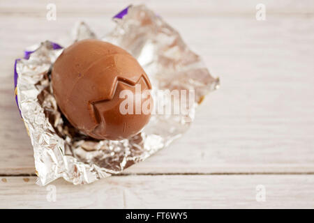 Small chocolate Easter eggs sat on a weathered wooden background Stock Photo