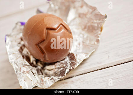 Small chocolate Easter eggs sat on a weathered wooden background Stock Photo