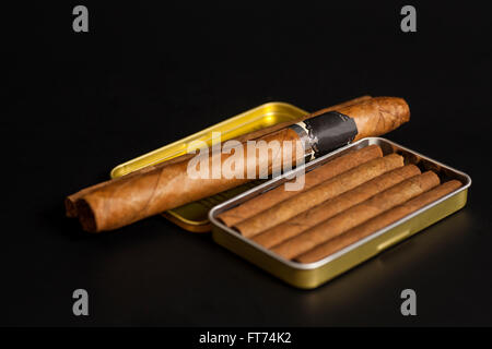 Open metal cigar box and cuban cigars on black background Stock Photo