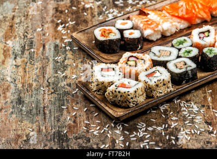 Sushi, maki, sashimi and sushi rolls on rustic wooden background Stock Photo