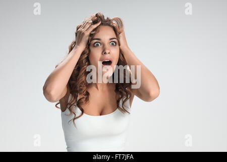 Portrait of young woman with shocked facial expression Stock Photo