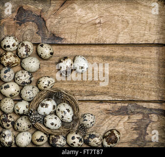 Vintage style Easter decoration. Eggs in nest on rustic wooden background Stock Photo