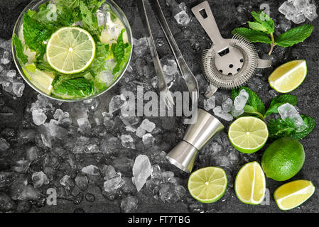 Cold drink glass with lime, mint leaves, ice. Mojito, caipirinha, lemonade, tonic water Stock Photo