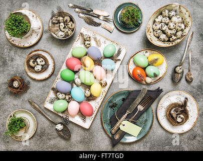 Easter table place setting decorated with colored eggs. Vintage style toned picture Stock Photo