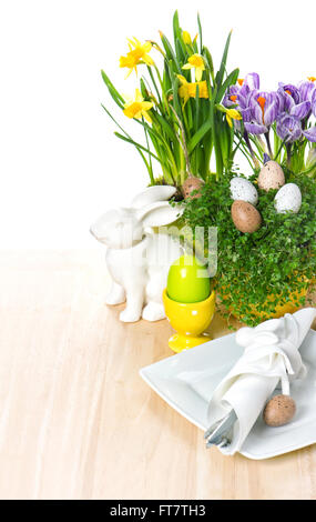 Easter table setting with flowers, bunny and eggs decoration on white background. selective focus