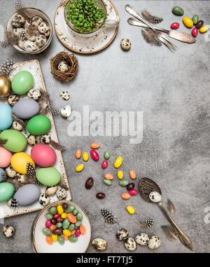 Easter table decoration with colored eggs and sweets. Holidays background with space for your text Stock Photo