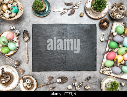 Easter table decoration with colorful eggs and slate plate for your text Stock Photo
