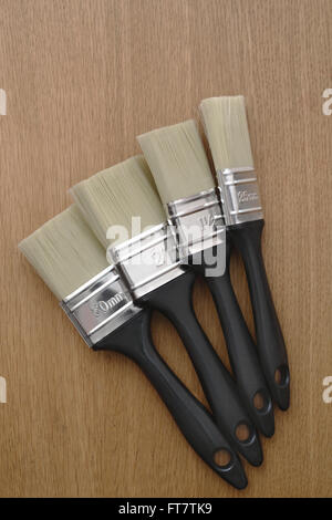 New paintbrushes on a wooden background. Stock Photo