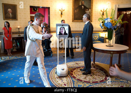 July 20, 2015 'During photo lines, there's this routine called 'push and pull.' One social aide helps push the next guest towards the President and another helps pull them out of the room. During a photo line to commemorate the 25th anniversary of the Americans With Disabilities Act, Alice Wong, Disability Visibility Project Founder, participated via robot. So after her photograph had been taken, social aides gestured to 'pull' her out of the room as the next guest entered.' (Official White House Photo by Pete Souza) Stock Photo