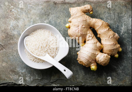 Raw white rice and ginger on gray stone slate background Stock Photo